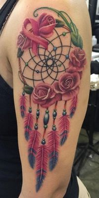  Tatouage attrape rêve avec des roses rouges et des plumes bicolores sur le haut du bras